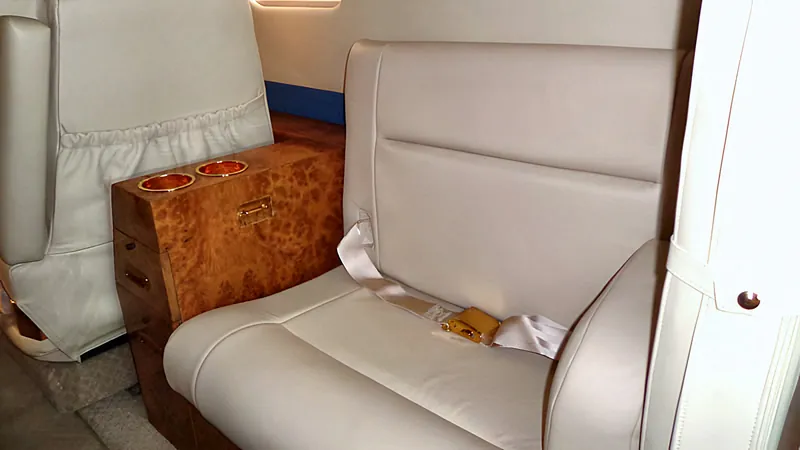 Burl side ledge beside a leather seat in a Sabreliner